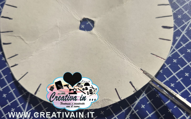 Ritaglio delle tacche perimetrali su un disco kumihimo di cartone.